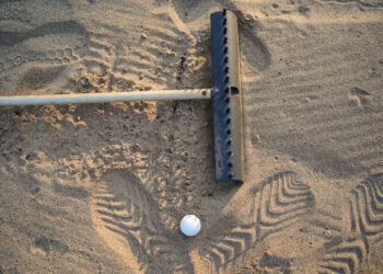 Can I rake a bunker while my ball is still in it? – National Club Golfer